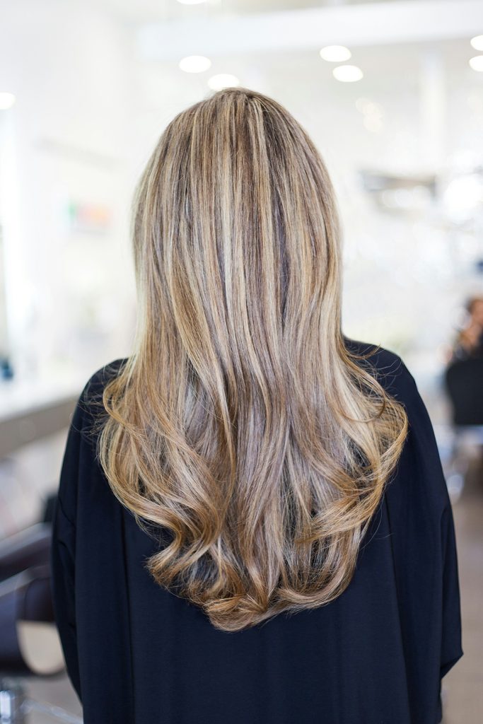 back view of woman's long highlighted blonde hair